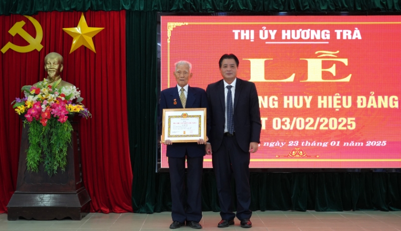 Bí thư Thị ủy Hương Trà Trần Công Phú trao huy hiệu 65 năm tuổi Đảng cho đảng viên Hồ Viết Sơ, đảng bộ phường Tứ Hạ